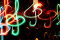 Close-up red and green neon glowing treble clefs. Abstract luminous background