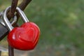 Close up of red heart-shaped love lock hanging on a bridge. Valentine's Day and Love concept. Royalty Free Stock Photo