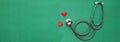 Close up red heart white stethoscope on green Doctor table.health concept.