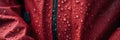 A close up of a red jacket with water droplets on it. Generative AI image. Royalty Free Stock Photo