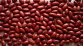 Close up of red kidney beans evenly scattered on table. Top view. Background texture of uncooked kidney beans. Copy