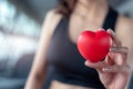 Close up of red massage ball like heart shape in fitness woman hand at sport gym training center. Medical and healthcare of heart Royalty Free Stock Photo