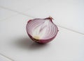 Close-up of a red onion, isolated on a clean white ceramic tile background Royalty Free Stock Photo
