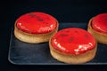 Close-up of red pastry tarts on a black background. Royalty Free Stock Photo