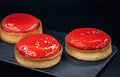 Close-up of red pastry tarts on a black background. Royalty Free Stock Photo