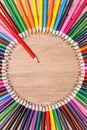 Close up of a red pencil standing out from a circle of many colorful pencils. Royalty Free Stock Photo