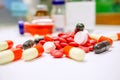 Close up of Red pill medicines and capsule place on white table with ampule blurry background