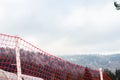 Close-up of red plastic fence for ski slopes against mountains