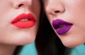 Close up of red and purple lips of two women. Cosmetics, makeup, lipstick, lip gloss, facial care. Royalty Free Stock Photo