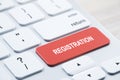 Close up of red registration button on white keyboard placed on blurry wooden desktop. concept.