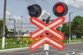 Close-up, red road sign at a railway crossing. Attention motorists. Against the backdrop of the blue sky and the road