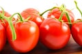 Close up of red tomatoes on a wooden surface and white background Royalty Free Stock Photo