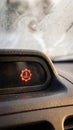 Close up of red transmission temperature warning light on dusty car dashboard. Symbol indicates engine or gearbox overheating Royalty Free Stock Photo