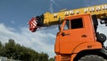 Close up for red truck crane on blue sky and forest background. Scene. Mobile crane standing in countryside.