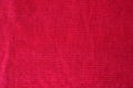 Red velvet fabric texture background. Fragment of a dark red cloth material