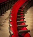 Close up of red theater seats in rows with no people in them Royalty Free Stock Photo