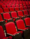 Close up of red velvet theater seats in rows with no people in them Royalty Free Stock Photo