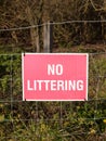 Close up of red and white country sign no littering