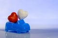 Close-up. Red and white heart in a blue cabriolet car on a light background. Concept love and auto. Valentine`s Day for motorists