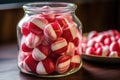 close-up of red and white peppermint candy in a glass jar