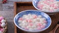 Close up of red and white tangyuan in blue bowl on wooden background for Winter solstice