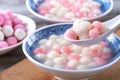 Close up of red and white tangyuan in blue bowl on wooden background for Winter solstice