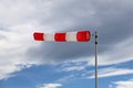 close up of red and white windsock indicator on cloudy sky Royalty Free Stock Photo