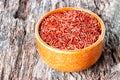 Close-up of red wild rice in a ceramic plate on an old wooden background. Concept of healthy nutrition and vegetarianism Royalty Free Stock Photo