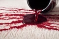 close-up of red wine spill soaking into white carpet fibers Royalty Free Stock Photo