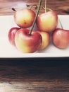 Close up on red and yellow cherries on a white plate