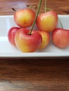 Close up on red and yellow cherries on a white plate