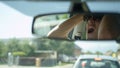CLOSE UP: Reflection of frustrated young man yelling at car in front of him. Royalty Free Stock Photo