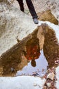 close up of the reflection on a water paddle of a hiker making an effort to climb the canyon on a mountain. The left leg of the