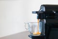 Close up of refreshing espresso pouring of capsule machine into a cup at home. Concept of coffee break Royalty Free Stock Photo