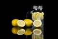 Close up of refreshing healthy lemonade in glass jar and fresh sliced lemons with black background Royalty Free Stock Photo