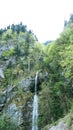 Refreshing waterfall flowing down moss covered brown stones in a beautiful green forest in Montenegro. Cinematic shot Royalty Free Stock Photo