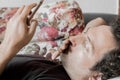 Close up of a relaxed Caucasian man using smart phone lying on couch in the living room at home Royalty Free Stock Photo