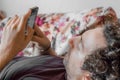 Close up of a relaxed Caucasian man using smart phone lying on couch in the living room at home Royalty Free Stock Photo