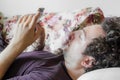 Close up of a relaxed Caucasian man using smart phone lying on couch in the living room at home Royalty Free Stock Photo