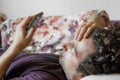 Close up of a relaxed Caucasian man using smart phone lying on couch in the living room at home Royalty Free Stock Photo