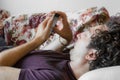 Close up of a relaxed Caucasian man using smart phone lying on couch in the living room at home Royalty Free Stock Photo