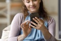 Close up relaxed millennial woman using smartphone.