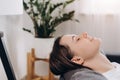 Close up of relaxed pretty young woman lying on comfortable sofa with closed eyes, daydreaming napping resting or meditating,