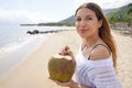 Close-up of relaxed woman drinking fresh coconut water on the beach enjoying a summer breeze Royalty Free Stock Photo