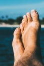 Close-Up of a Relaxing Barefoot With Toes Up Against a Sunny Beach Background and flip flop tan marks Royalty Free Stock Photo