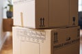 Close Up Of Removal Boxes Stacked In Lounge Ready For Moving In Or Moving Out Of Home