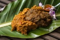 Close-up of Rendang served on a banana leaf, with its rich and aromatic curry sauce complemented by the natural freshness of the