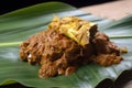 Close-up of Rendang served on a banana leaf, with its rich and aromatic curry sauce complemented by the natural freshness of the