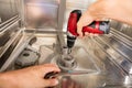 Close-up Of Repairman Fixing Dishwasher Royalty Free Stock Photo