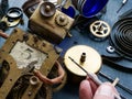 Close-up of a repairman hand assembling or repairing a vintage mechanical robot.